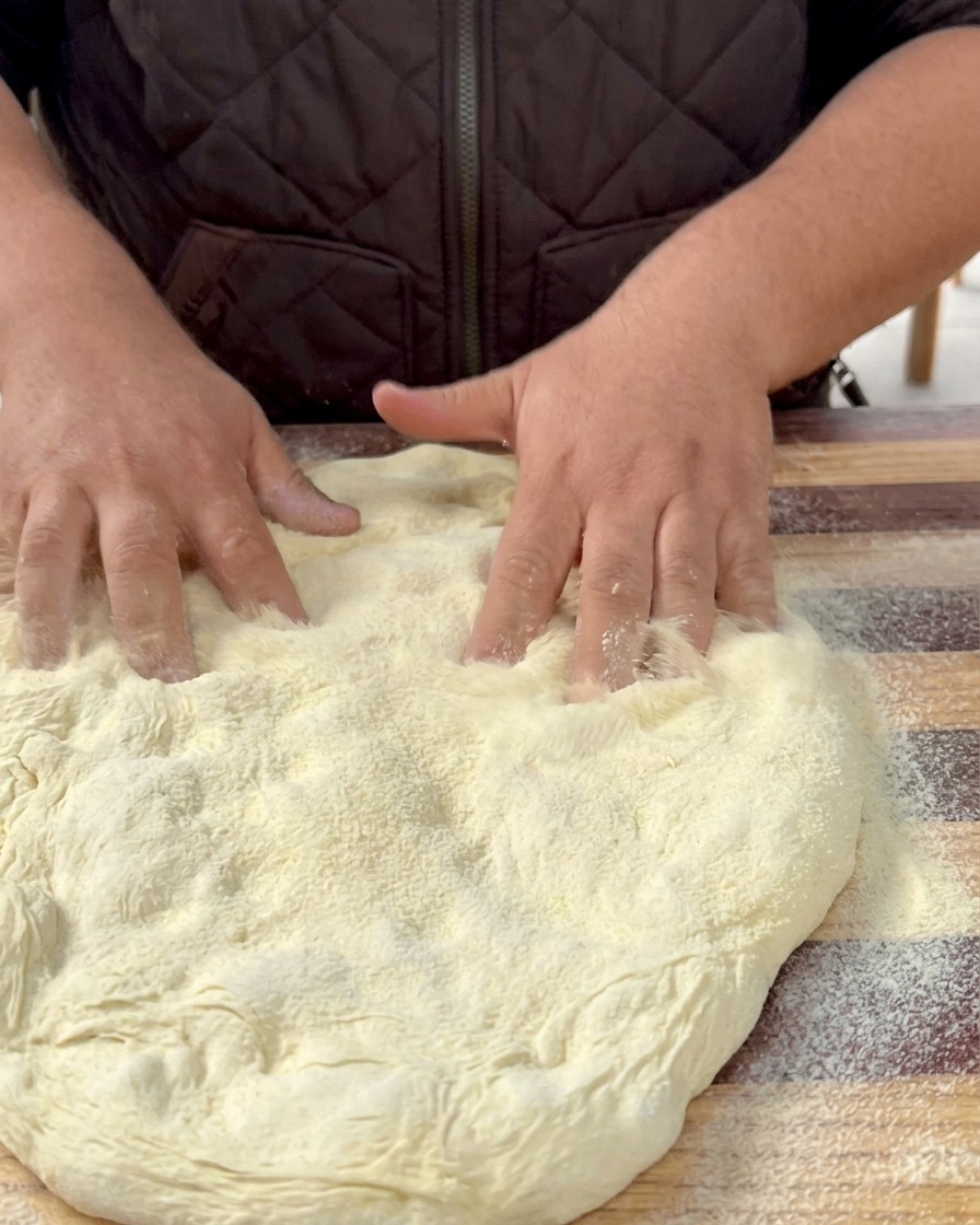 Masa estirada descansando sobre una bandeja de horno forrada con papel pergamino.