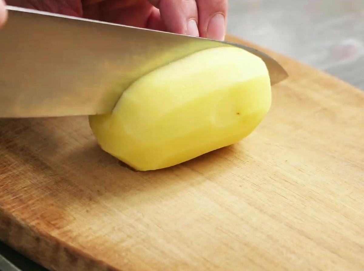 Trozos de patata cruda preparados sobre una tabla de madera.
