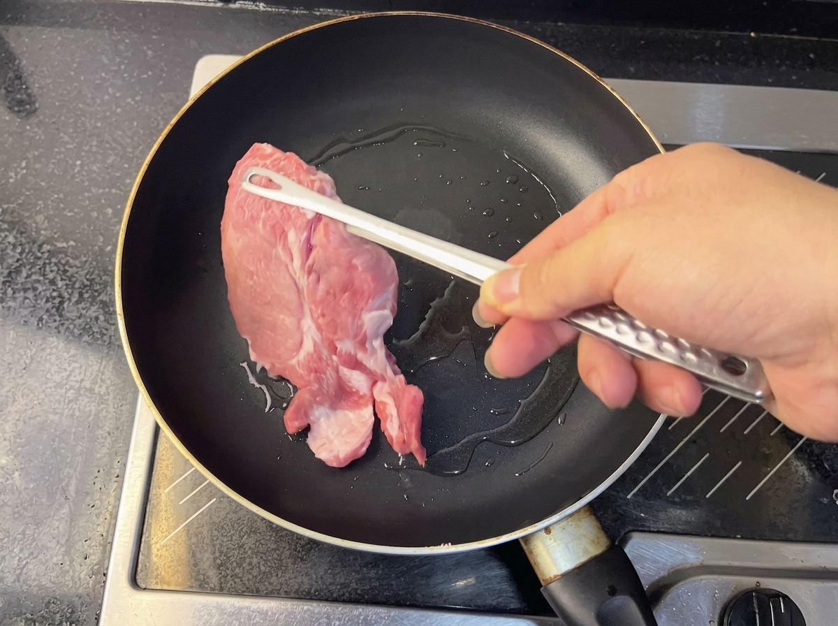 Agua caliente de la cocción vertiéndose en un tazón con la base de sopa preparada.