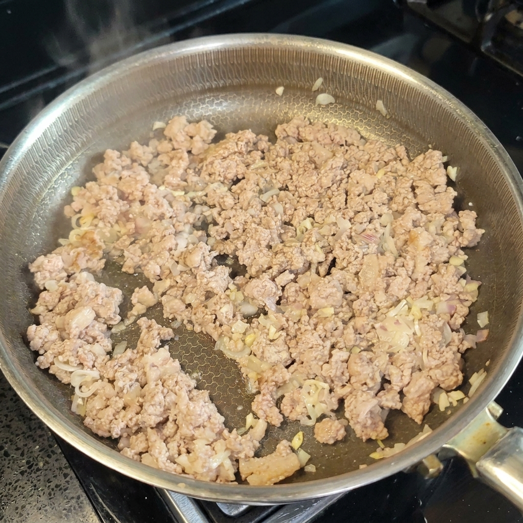 Vino de cocina y pasta de miso siendo integrados en la carne cocinada.