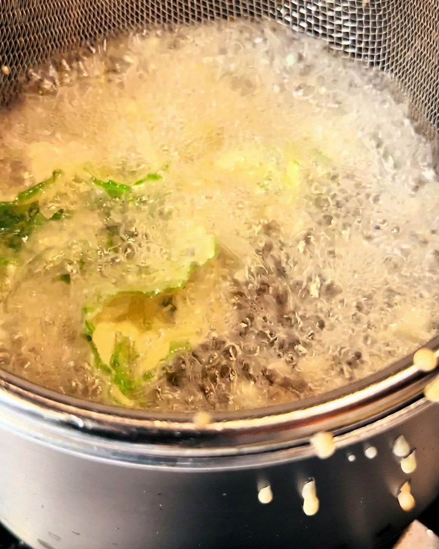 Verduras rebozadas friéndose en aceite caliente, doradas y crujientes.