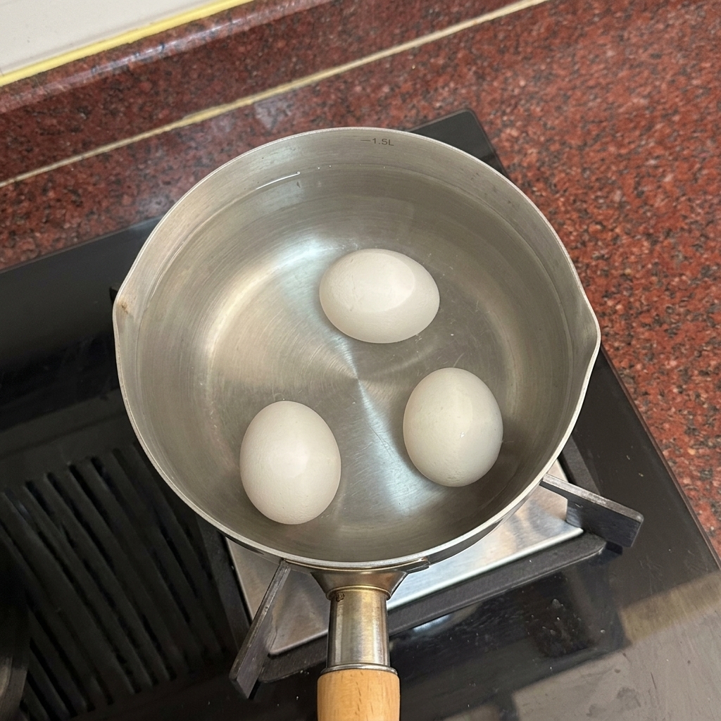 Tres huevos blancos reposando en el fondo de una olla llena de agua caliente y clara.