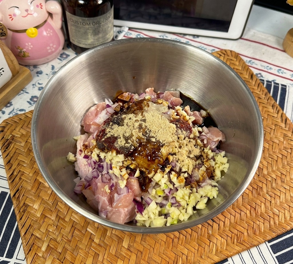 Salsa de ostras oscura y espesa cayendo desde una botella hacia un bol de pollo marinado con especias.