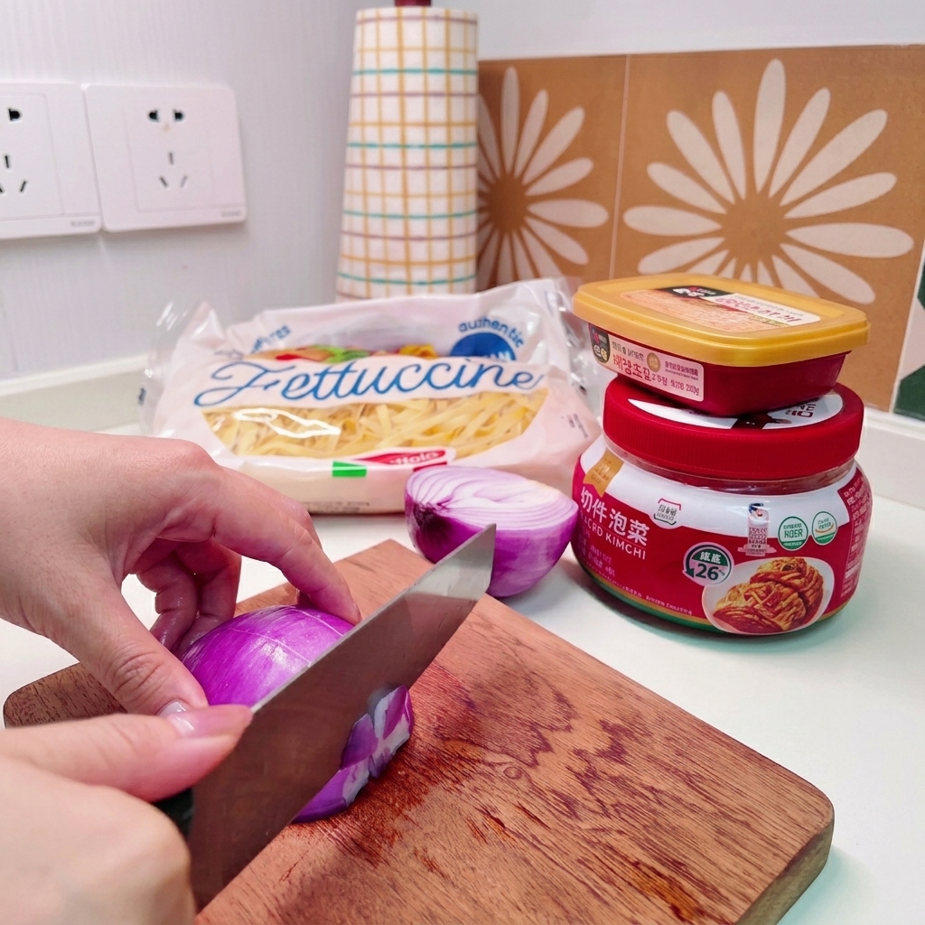 Primer plano de unas manos usando un cuchillo para cortar una cebolla morada en trozos pequeños sobre una tabla de madera.