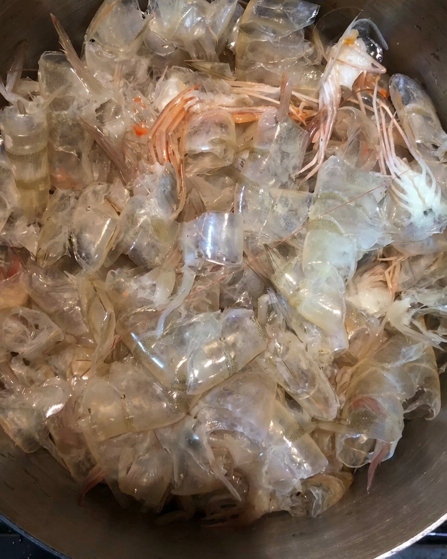 Primer plano de cáscaras frescas de gamba en una olla de metal.