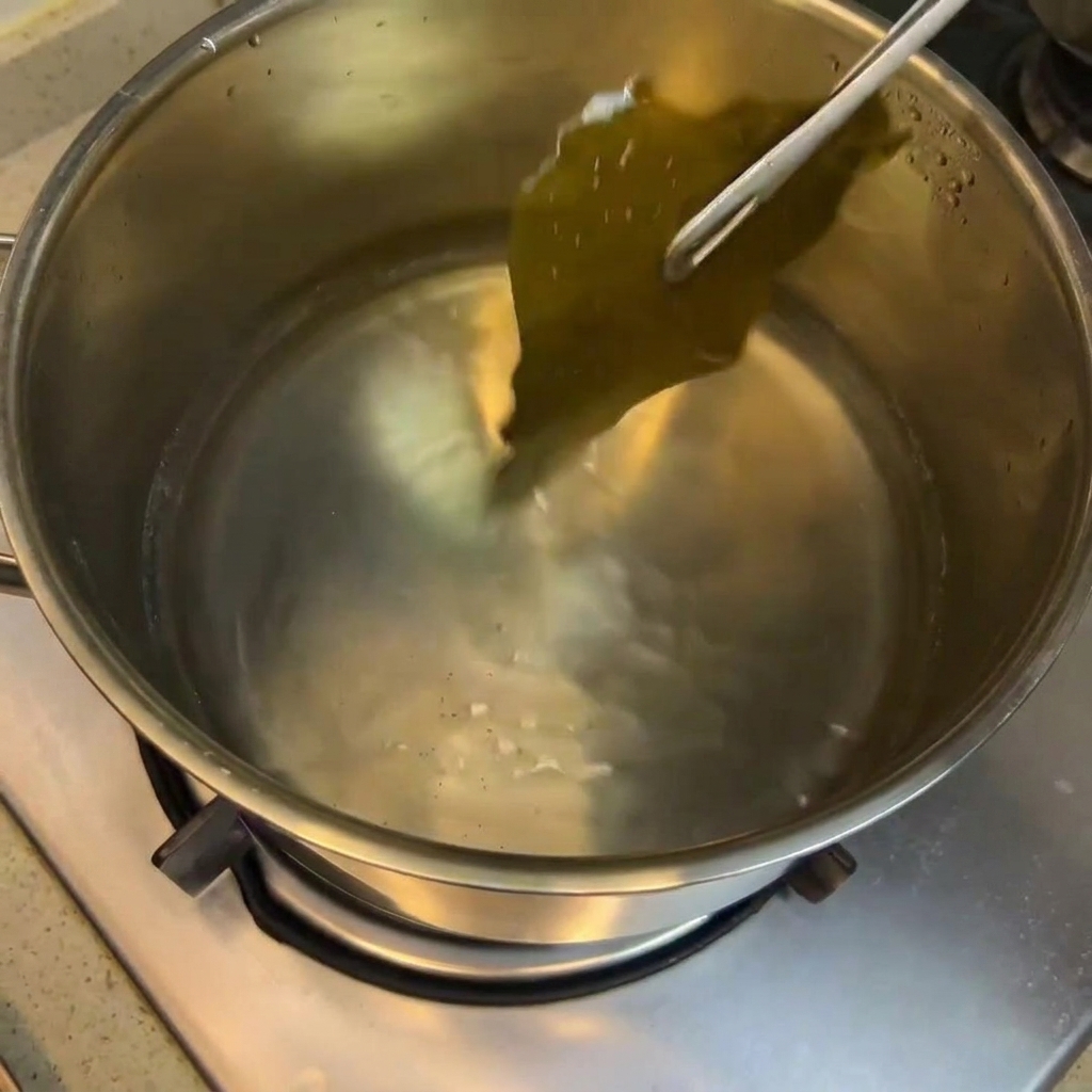 Salsa de soja, vino de arroz y azúcar siendo integrados en la olla con el caldo de alga.