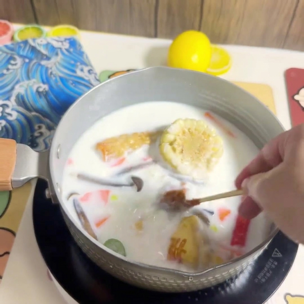Un bloque de fideos ramen siendo colocado en la olla de caldo hirviendo con los ingredientes.