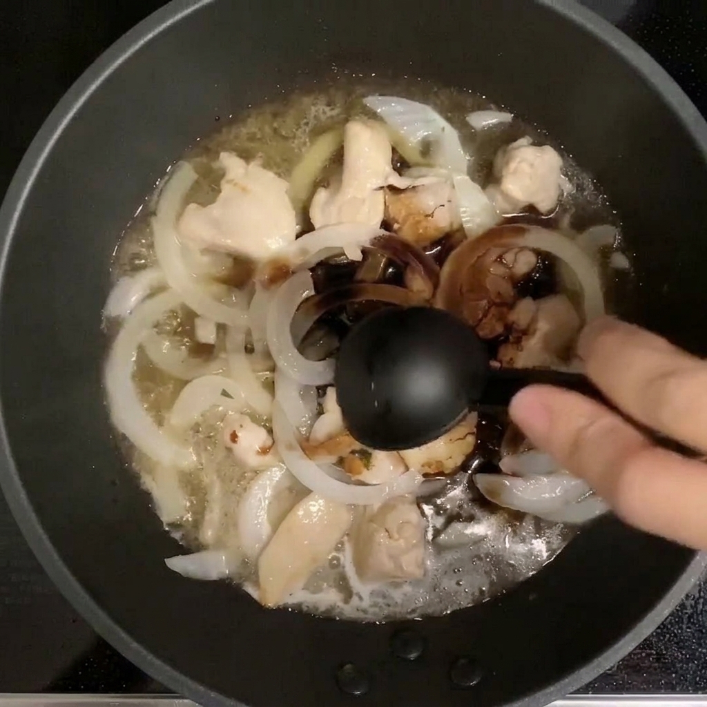 Cuchara medidora vertiendo condimentos en una sartén con pollo y cebolla hirviendo en dashi.