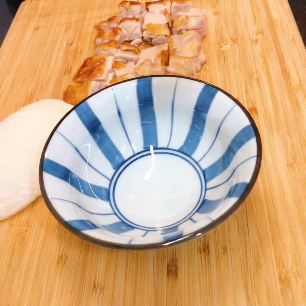 Mirin y salsa de soja mezclándose en un bol de cerámica a rayas azules y blancas.