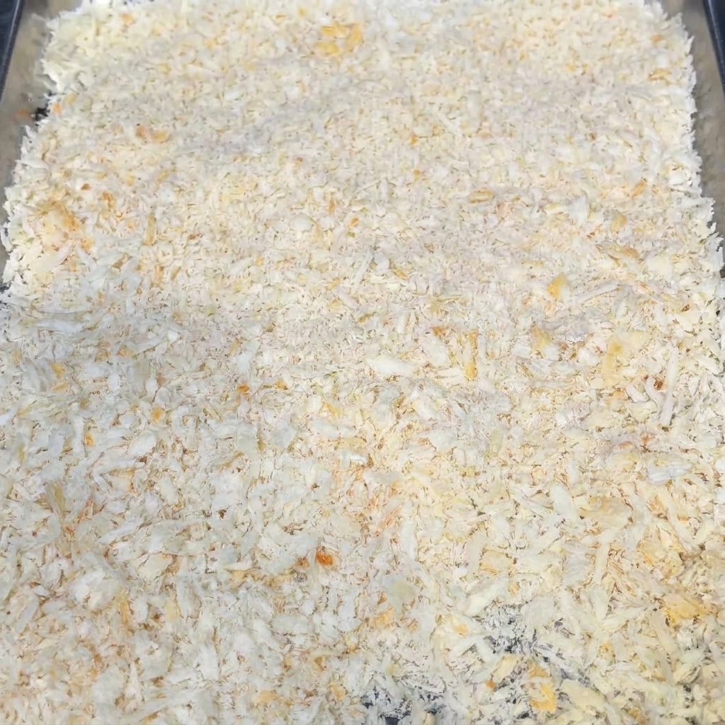 Una bandeja llena de pan rallado seco, mostrando su textura superficial.