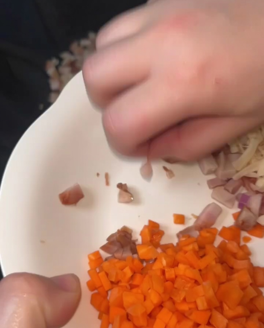 Salteando juntos cubitos de cerdo char siu y vieiras deshidratadas en un wok curado con manteca de cerdo derretida.