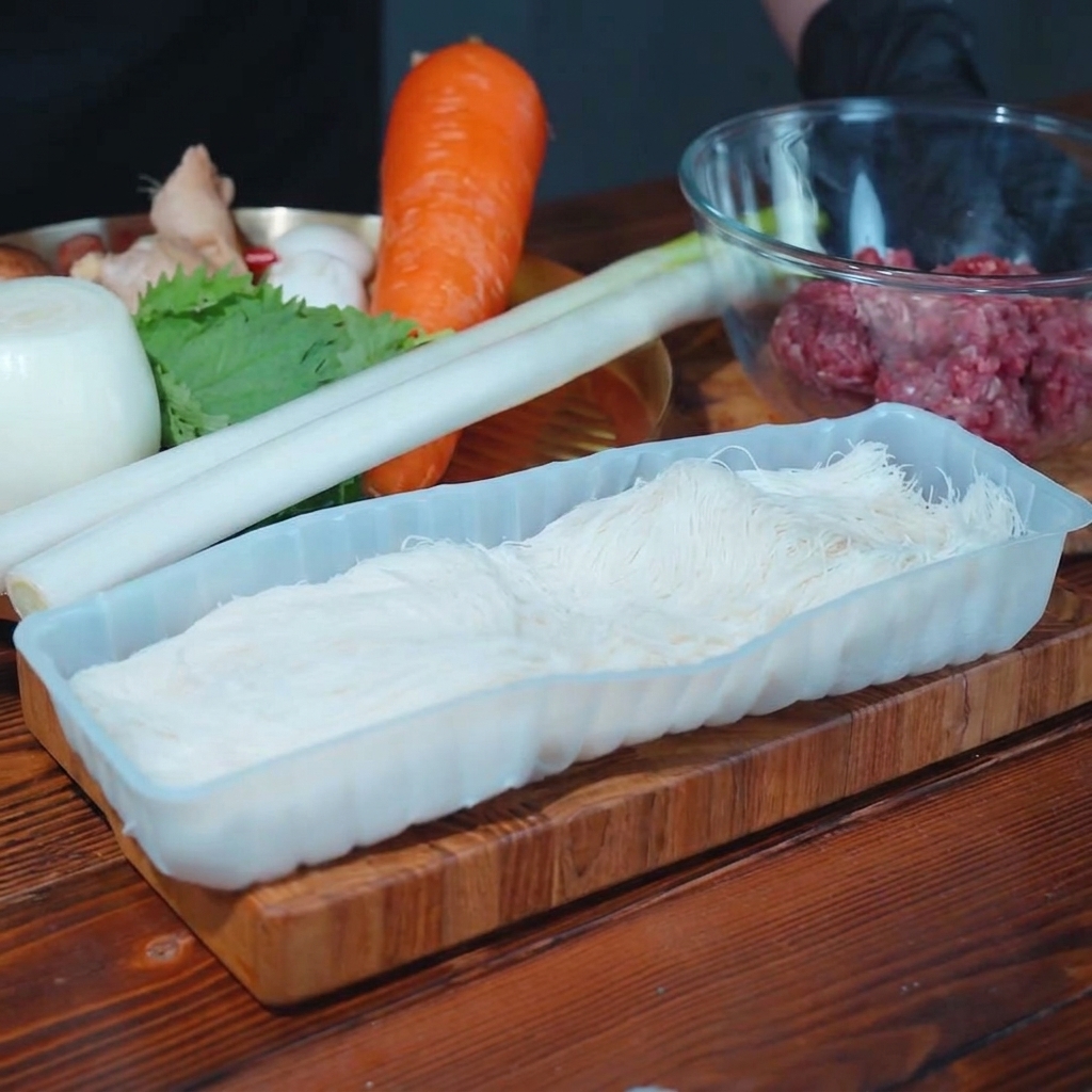 Puerro, setas shiitake y cebolla picados sobre una tabla de cortar de madera.