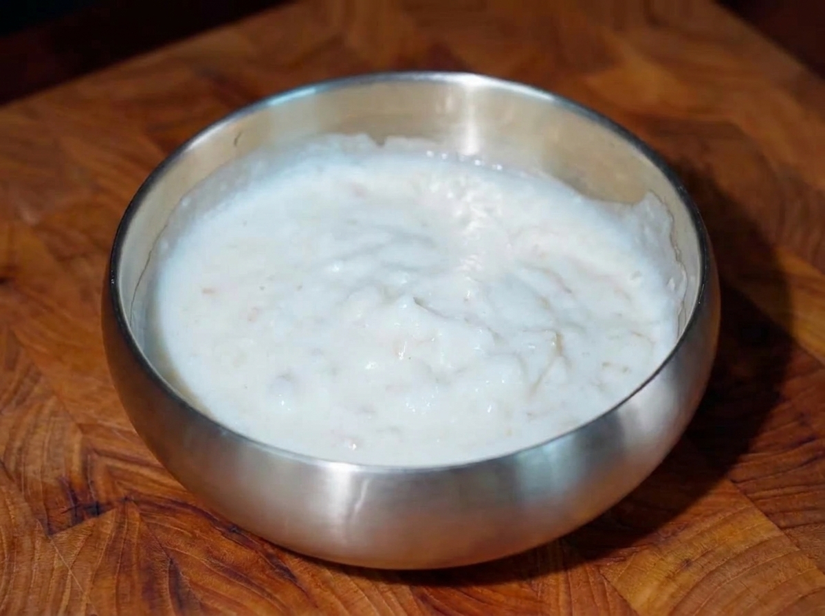Primer plano de los trozos de ternera frita con pequeños puntos de crema de osmanto encima.