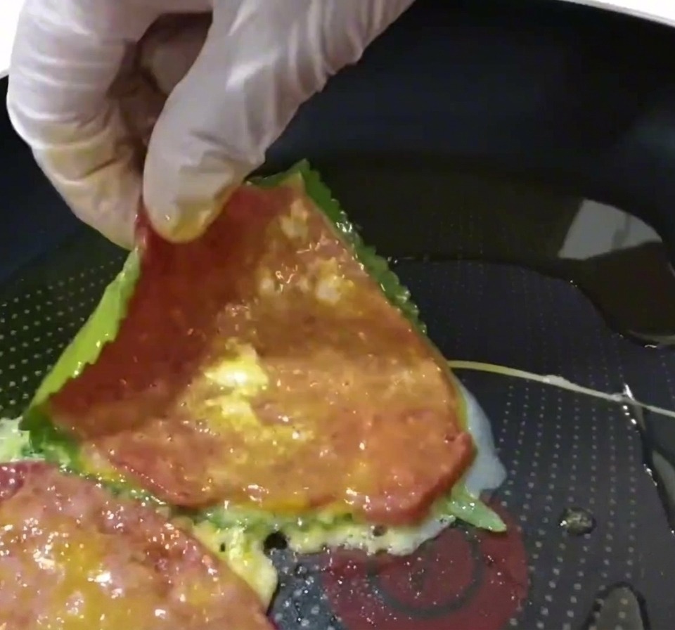 Una tortita de ternera y perilla colocándose en una sartén precalentada con aceite.