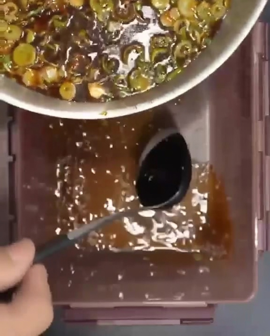 Costillas de res crudas dispuestas en un recipiente con el marinado vertido sobre ellas.
