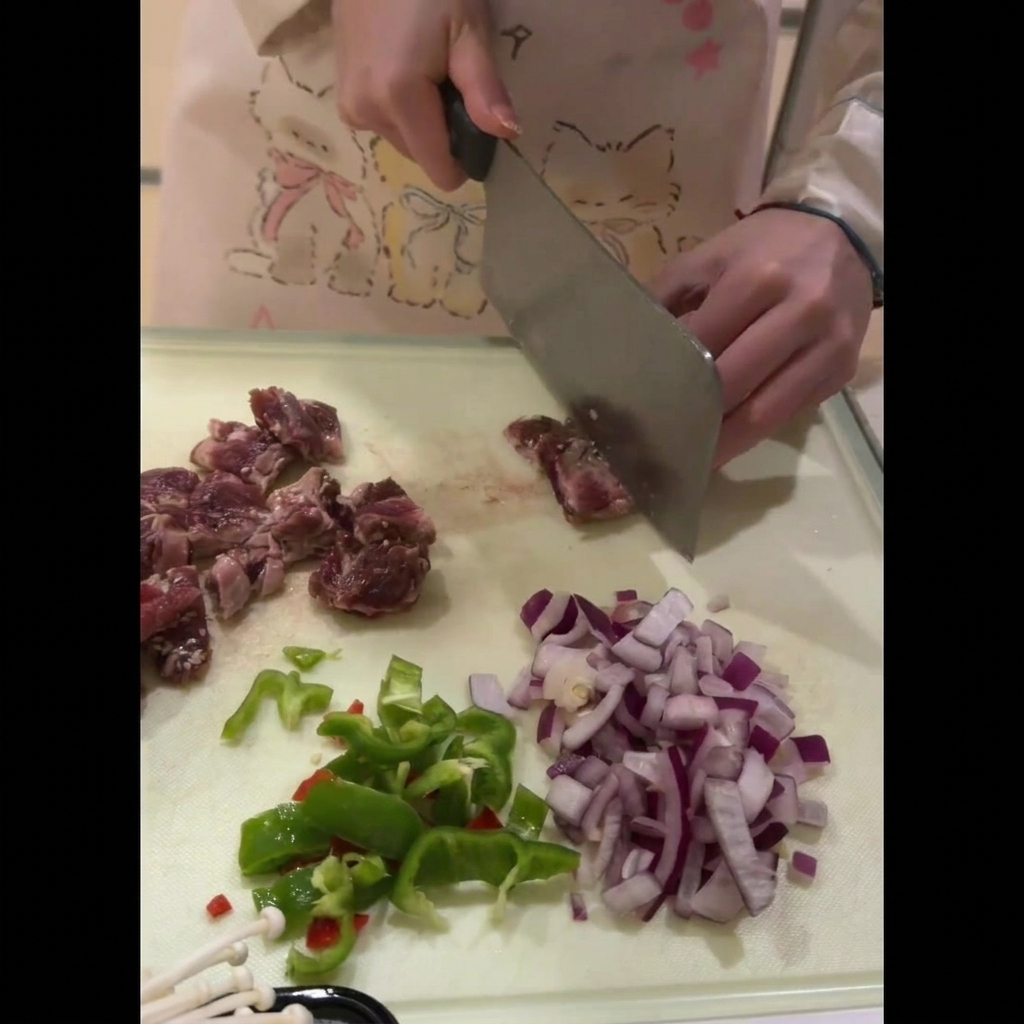 Costillas de ternera frescas cortadas cuidadosamente en trozos uniformes del tamaño de un bocado sobre una tabla de cortar.