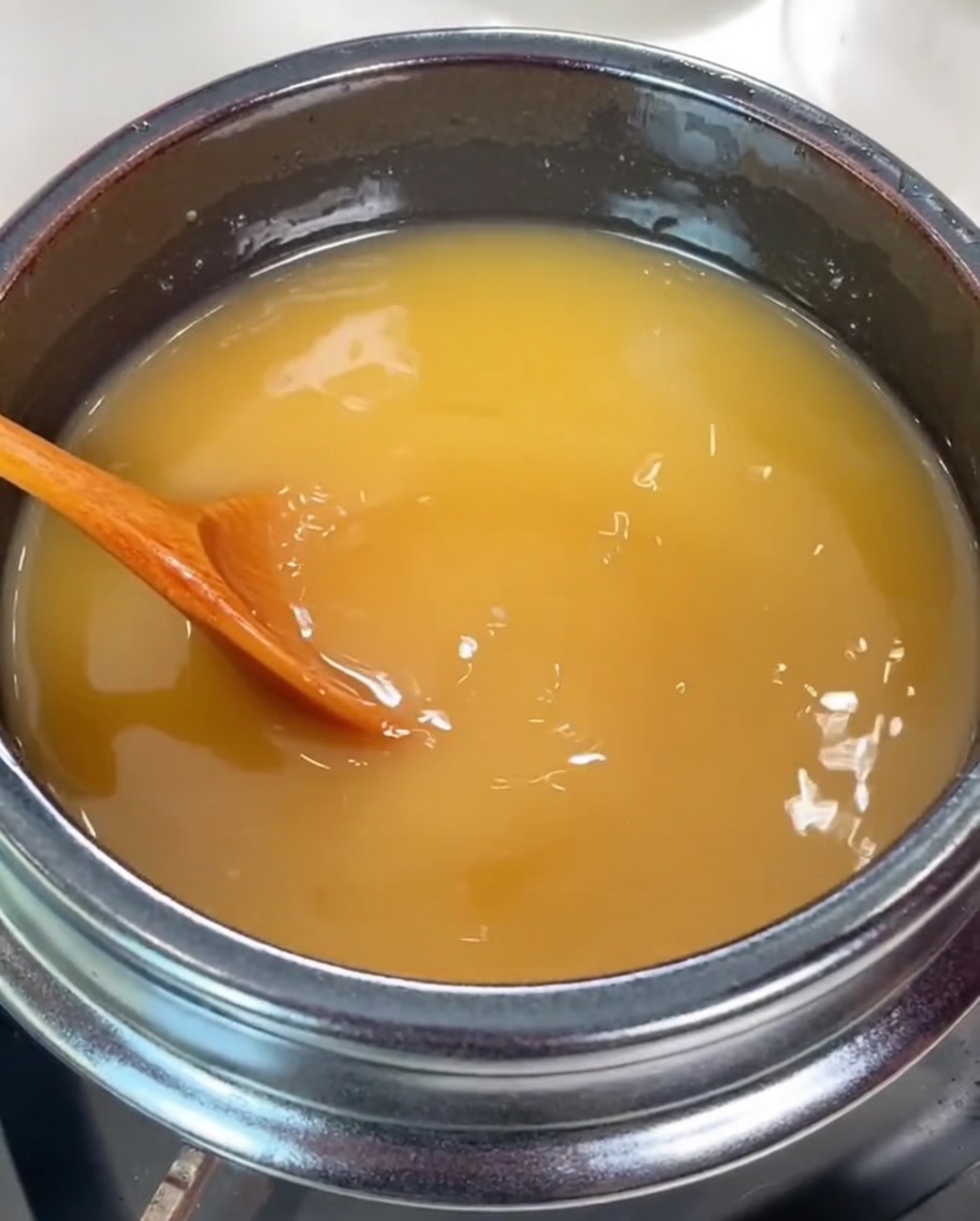 Almejas frescas y limpias siendo añadidas al caldo sazonado a fuego lento.