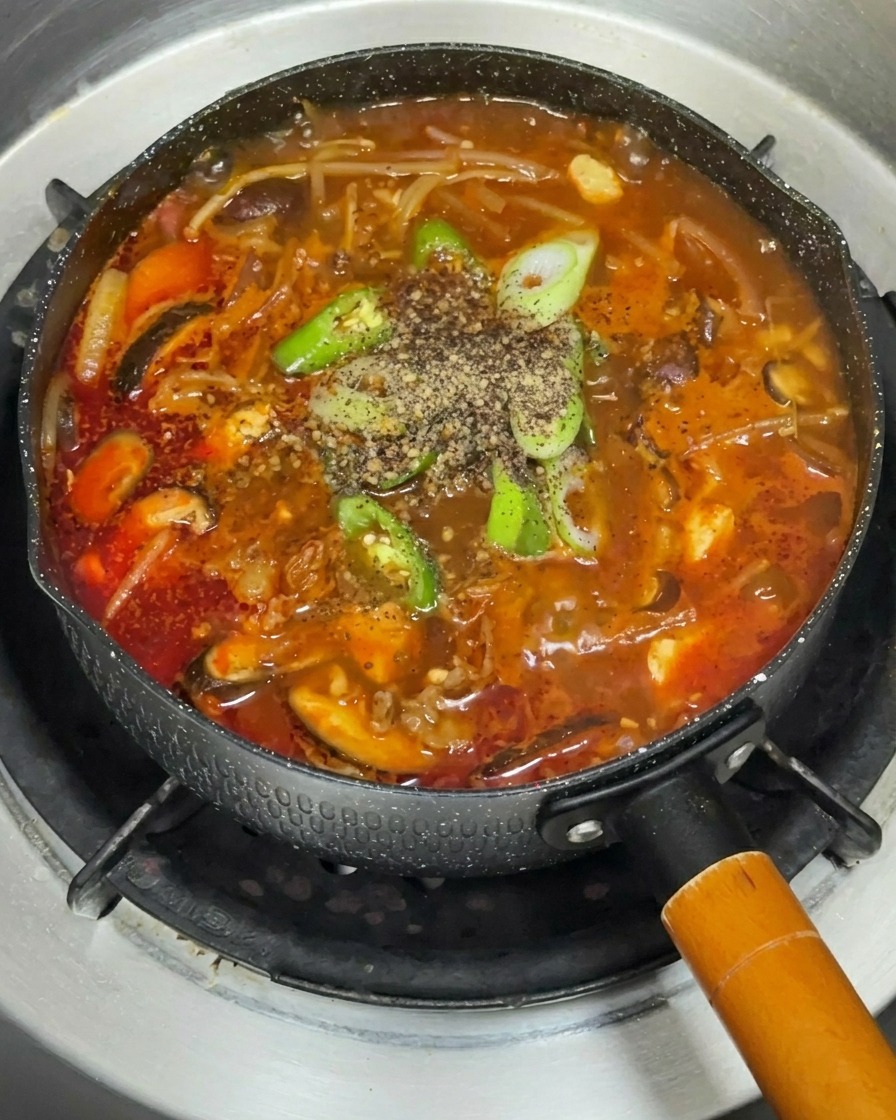 Una variedad de verduras frescas dispuestas en un plato, incluyendo setas, cebolla morada y brotes de soja.