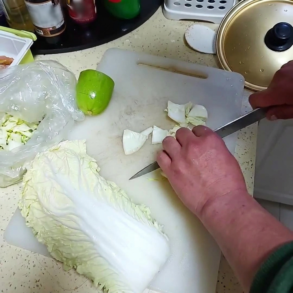 Cebolla fresca y un pequeño melón verde cortándose en trozos sobre una tabla de cortar blanca.