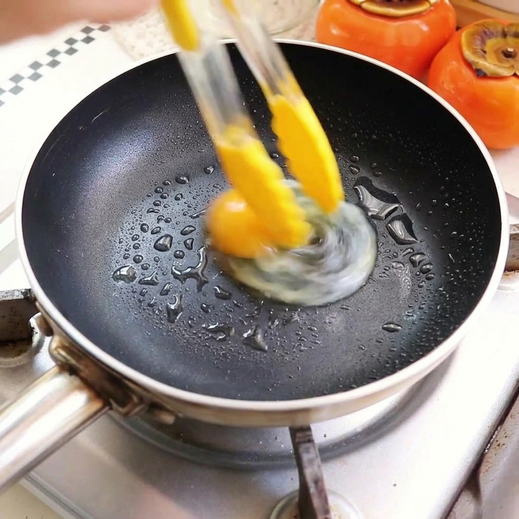 Huevos friéndose en una sartén con aceite caliente.