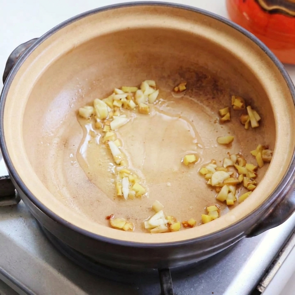 Trozos de huevo frito siendo transferidos a la olla de barro.