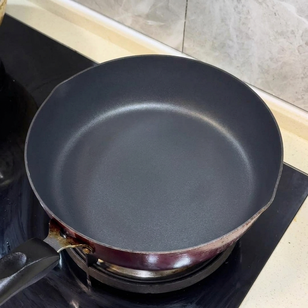 Tiras de cebollino y jengibre chisporroteando en aceite caliente en una sartén negra.
