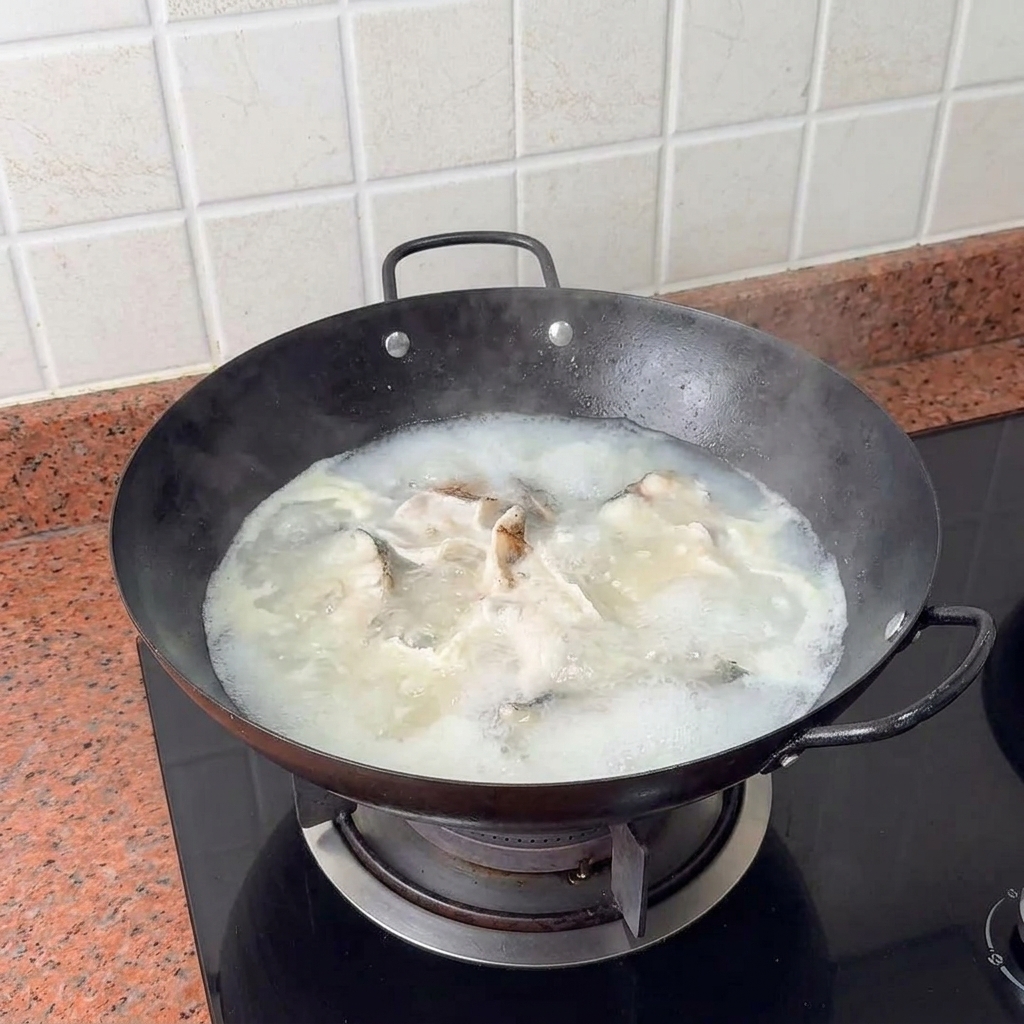 Cubos de tofu colocados suavemente en el caldo de pescado hirviendo.