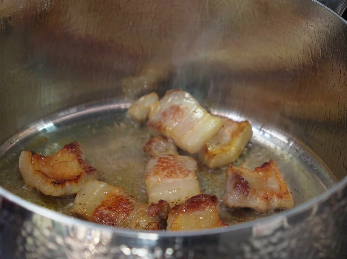 Ajo picado mezclándose con la grasa de la panceta.