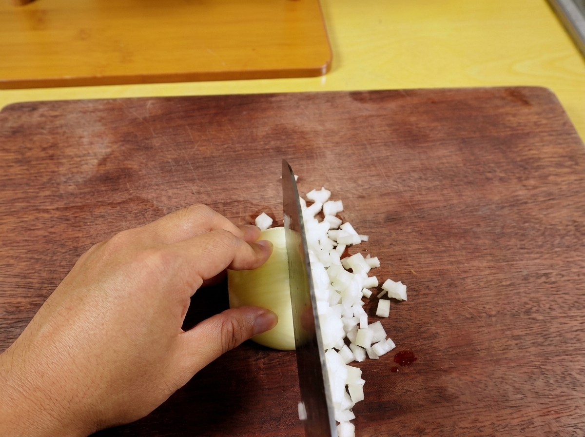 Chile verde fresco siendo picado finamente sobre una tabla de cortar de madera.