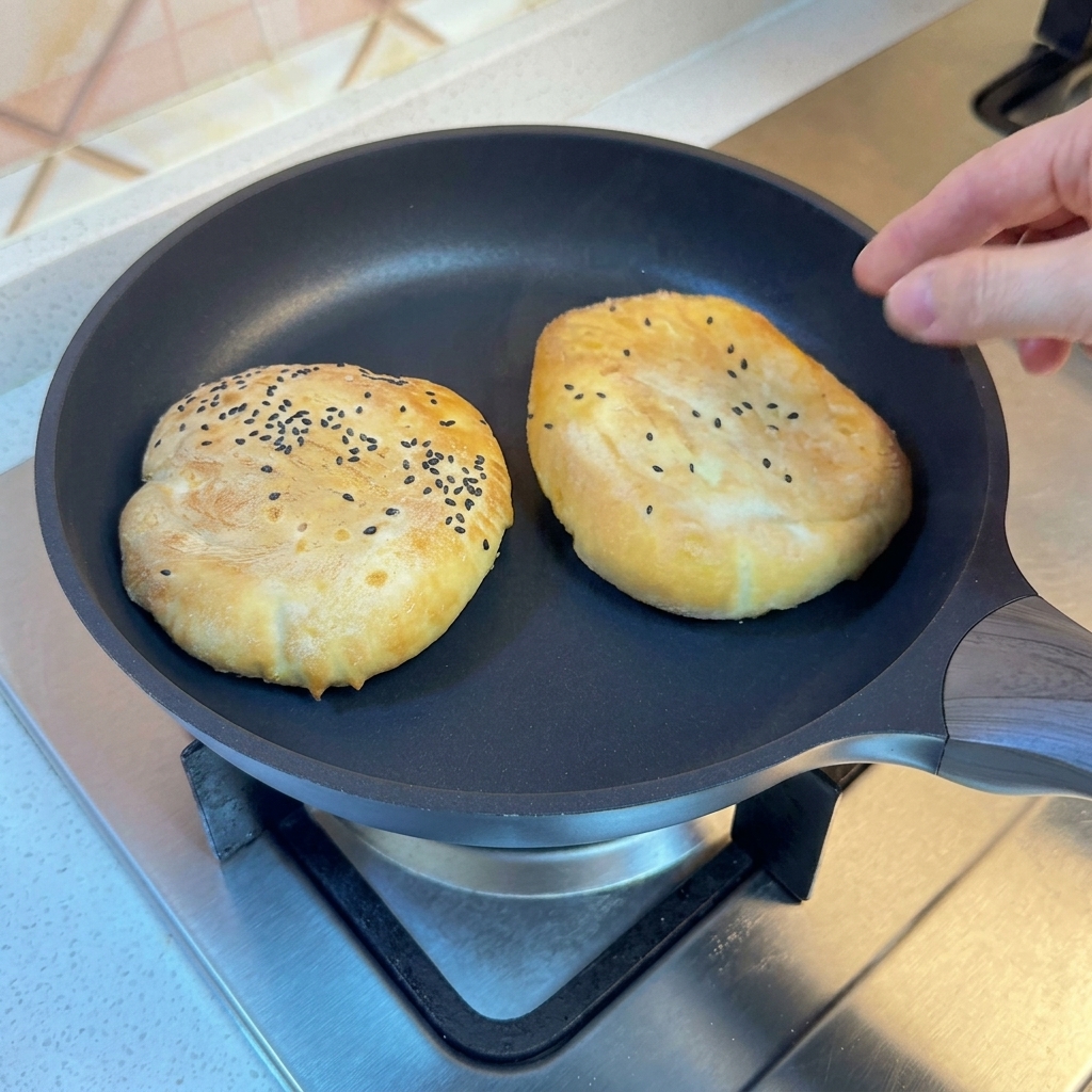 Panes en una sartén cubierta con una tapa, cocinándose al vapor.