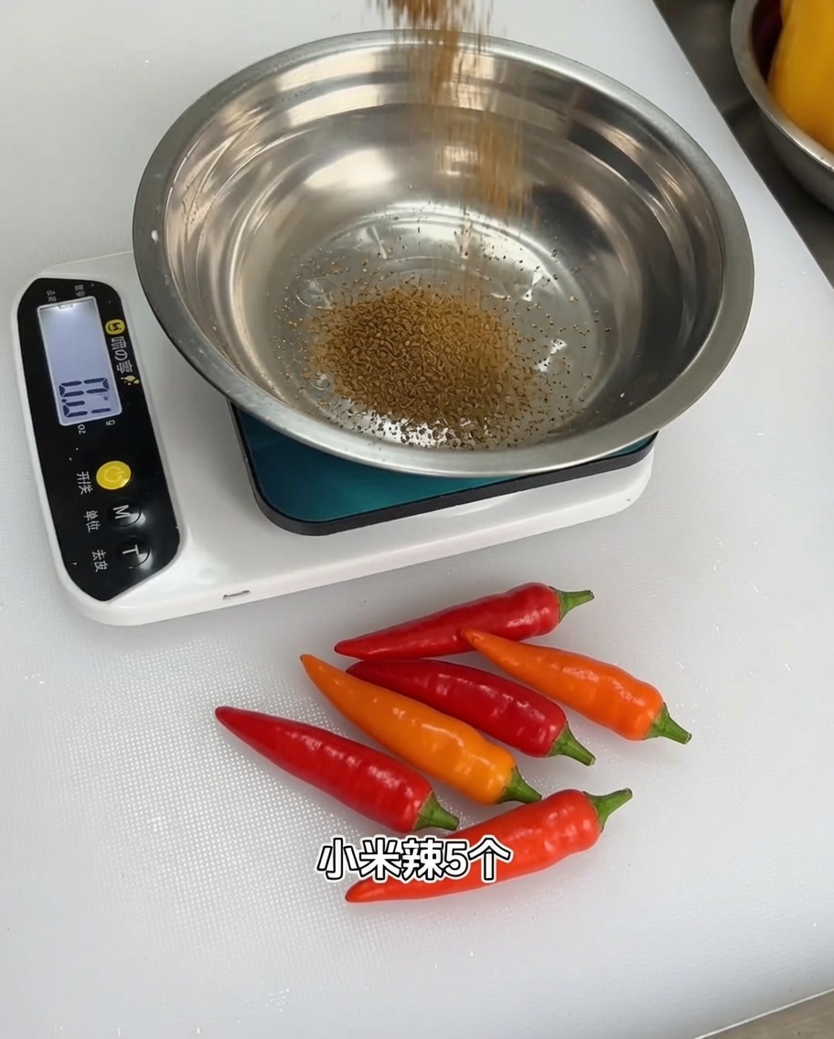 Una mezcla de polvos de especias aromáticas siendo medida en un tazón de metal sobre una báscula de cocina digital.