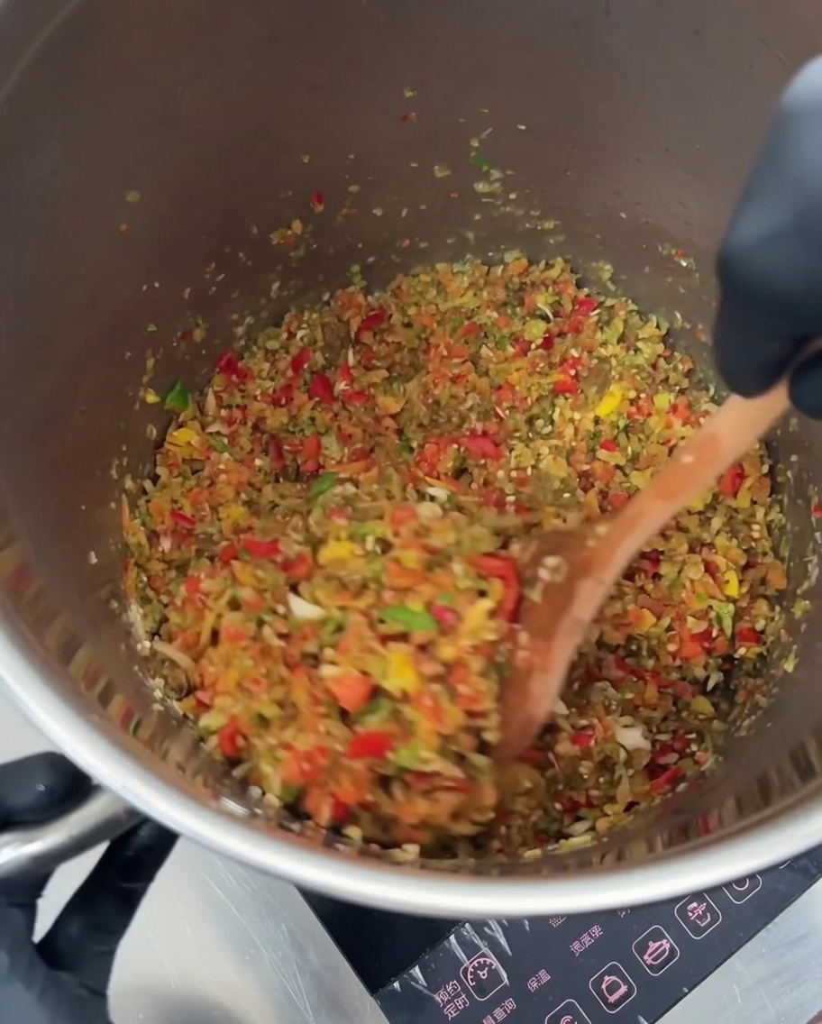 Frijoles rojos y granos de maíz dorado siendo mezclados en la mezcla de verduras salteadas.