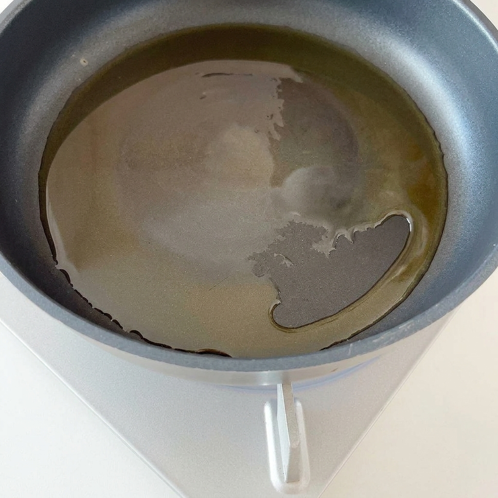 Cebolla morada picada cocinándose en una sartén caliente con aceite.