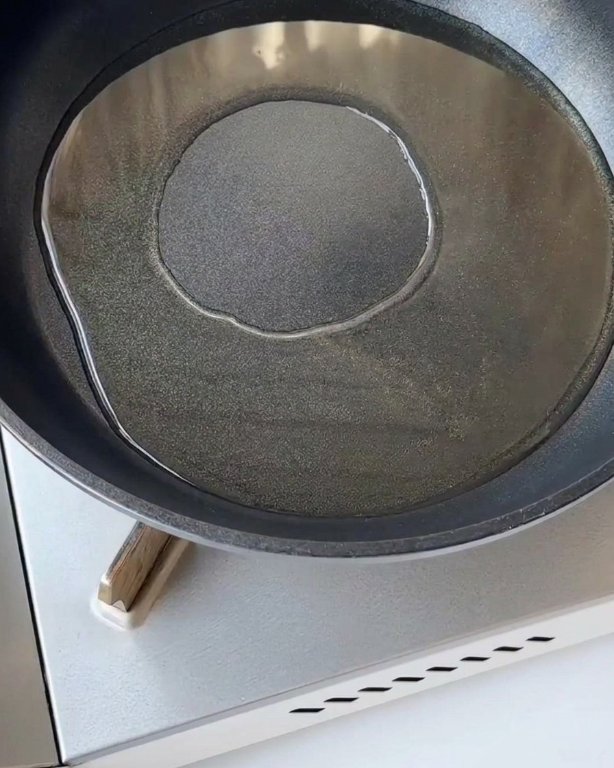 Cebolla morada picada salteándose en una sartén caliente con un poco de aceite.