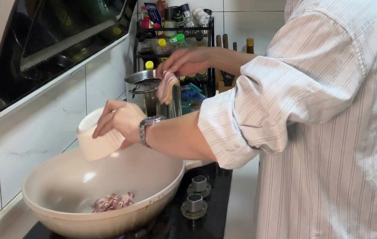 Trozos de bacon friéndose en una sartén hasta quedar dorados.