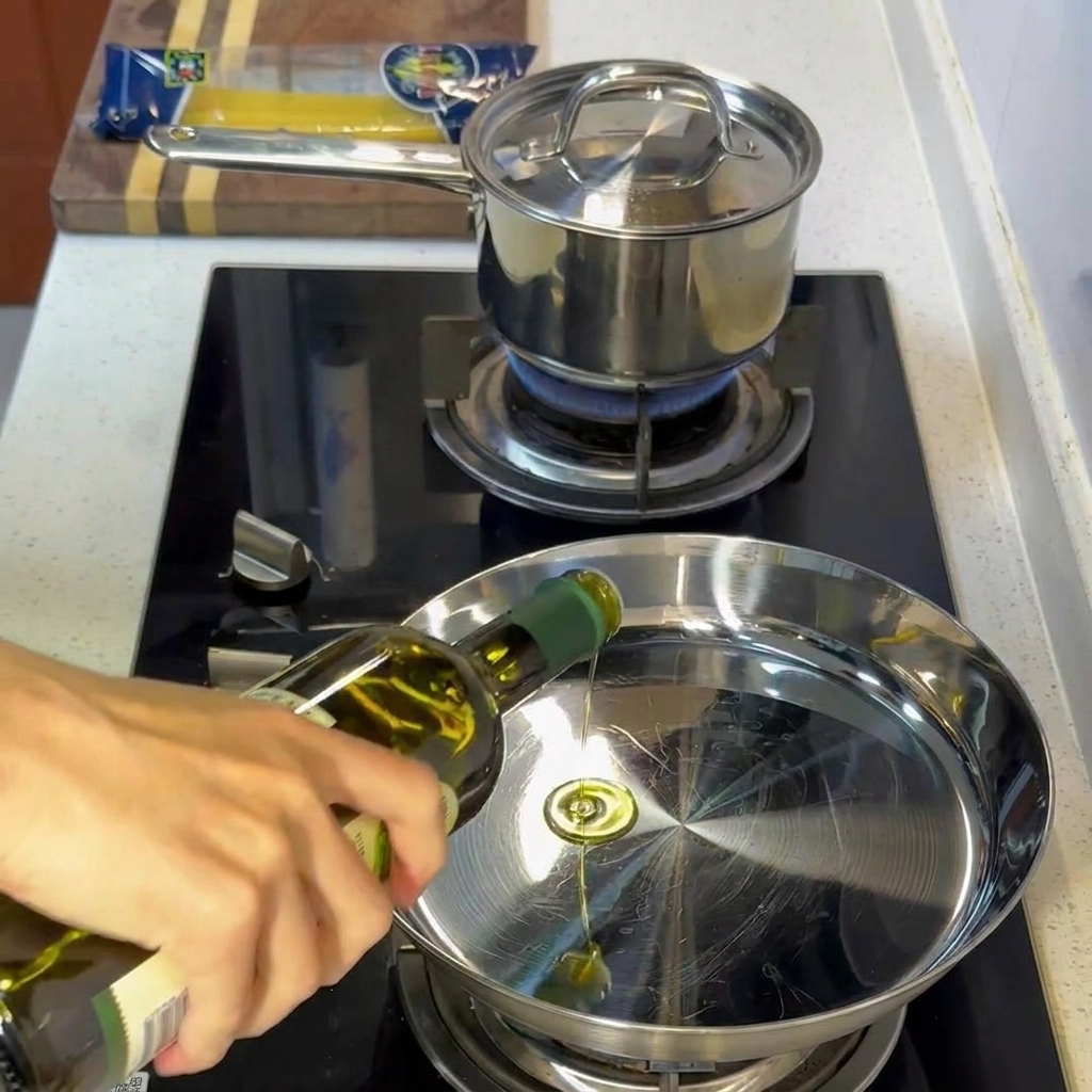 Aceite de oliva brillante en una sartén de acero inoxidable caliente.
