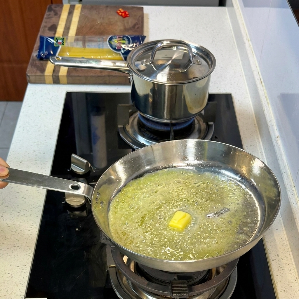 Mantequilla derritiéndose y burbujeando en la base de aceite de oliva caliente.
