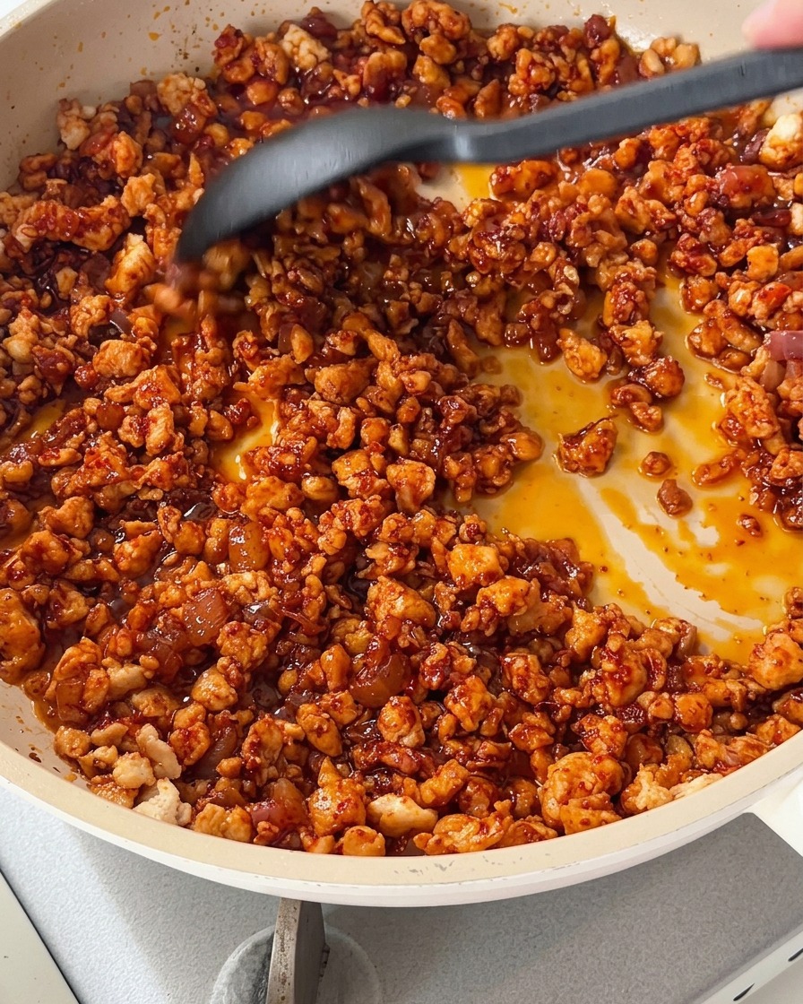 Cocinando la mezcla de pollo con pimientos picados de colores en una sartén.