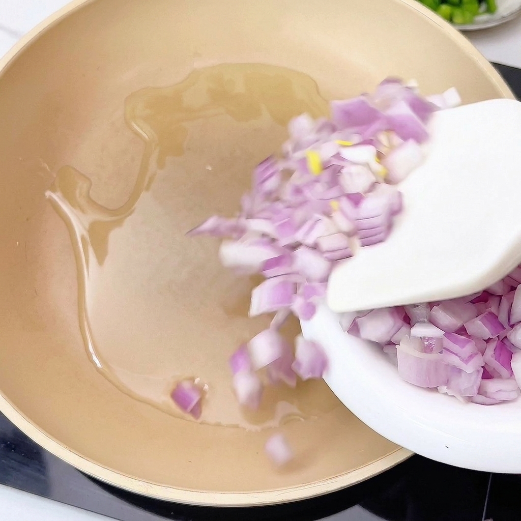 Cebolla y ajo siendo sofritos en una sartén con aceite caliente.