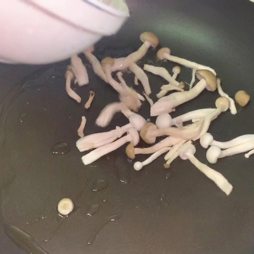 Champiñones frescos salteándose en una sartén con aceite hasta dorarse.