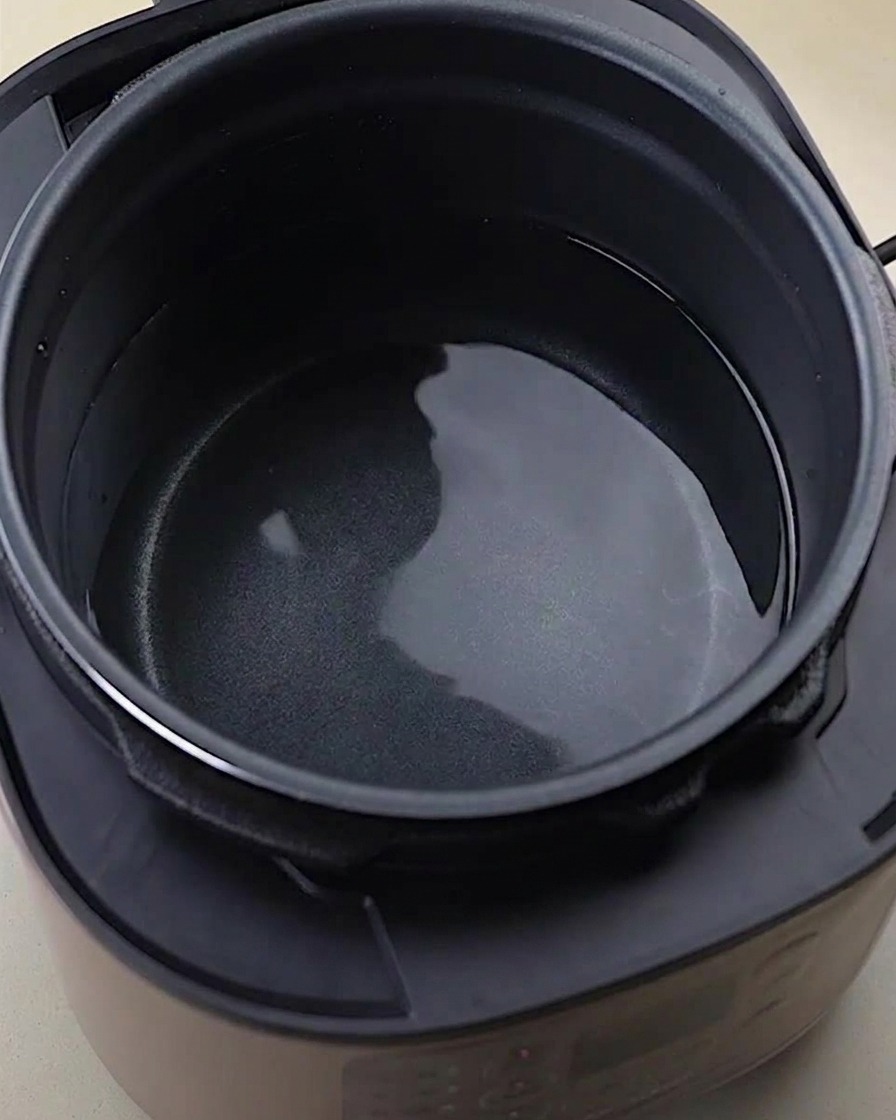 Carcasas, alitas y patas de pollo en una olla a presión con agua