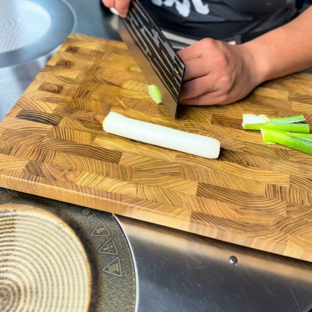 Trozos finamente picados de cebolleta fresca listos para usar sobre una tabla de cortar de madera.