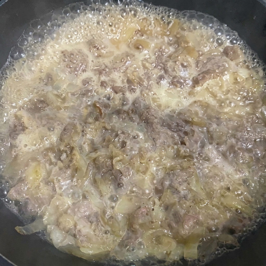 Retirando la espuma de la superficie del guiso con una espumadera.