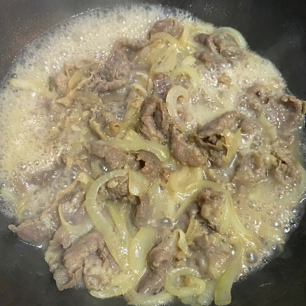 Añadiendo salsa de soja, azúcar y sal a la mezcla de ternera y cebolla.