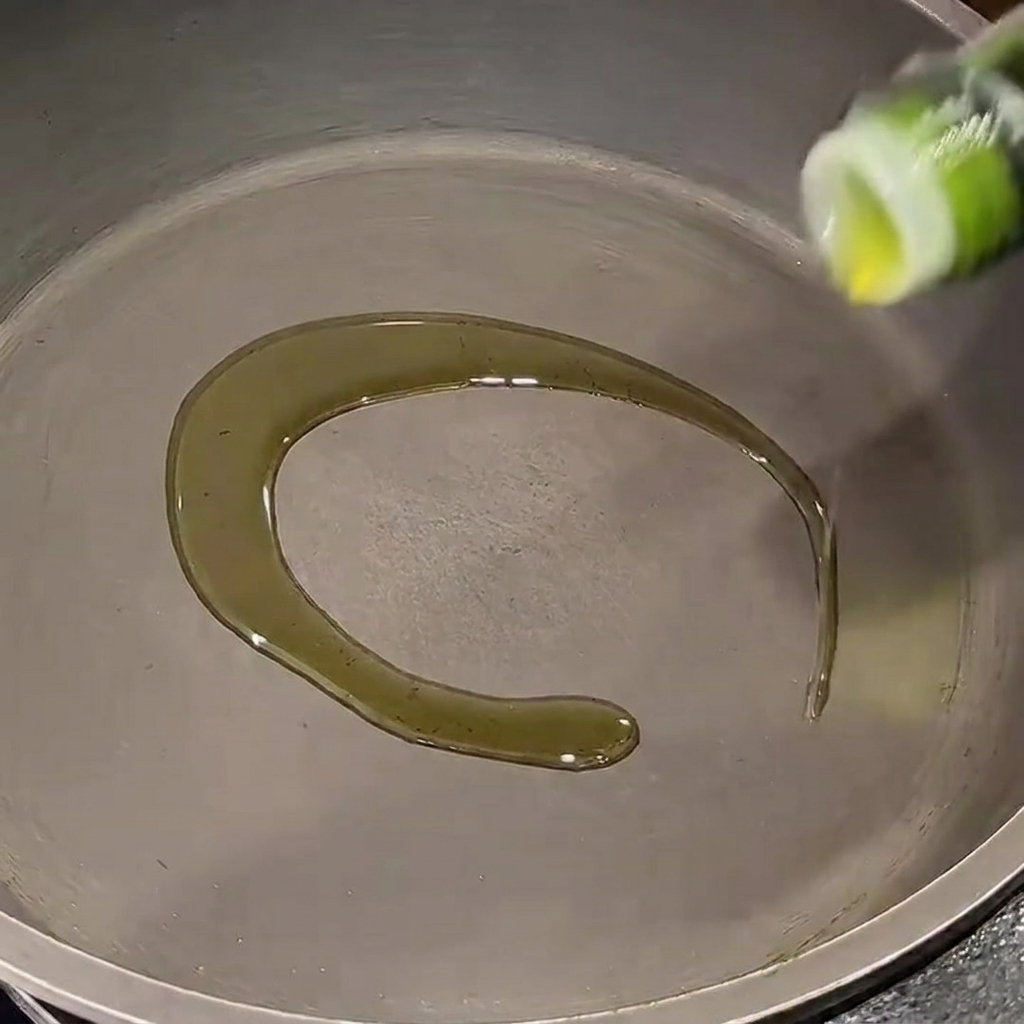 Cebollas rojas picadas ablandándose en una sartén con aceite de oliva.