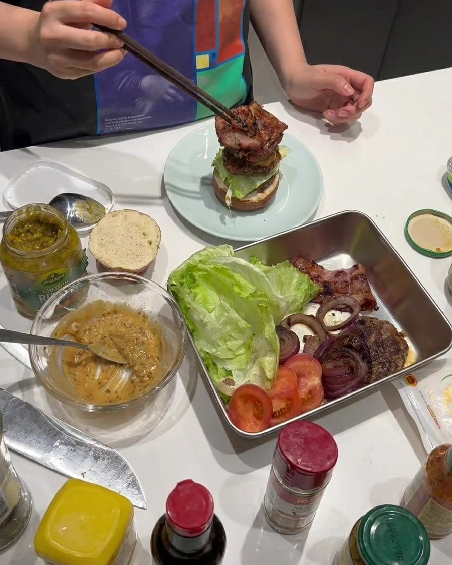 Tiras de tocino crujiente añadidos al armado de la hamburguesa.