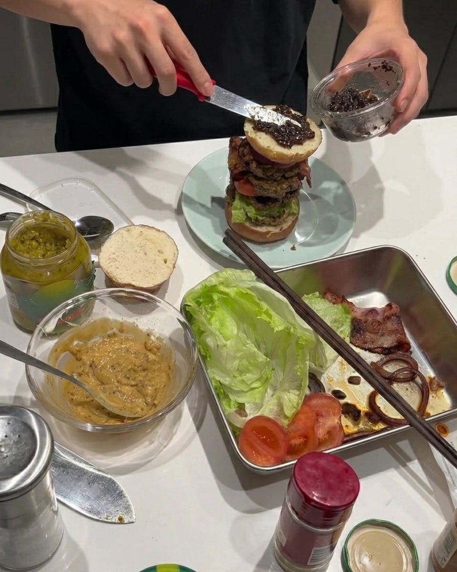 Pasta de trufa negra extendiéndose sobre los aros de cebolla fritos en la hamburguesa.