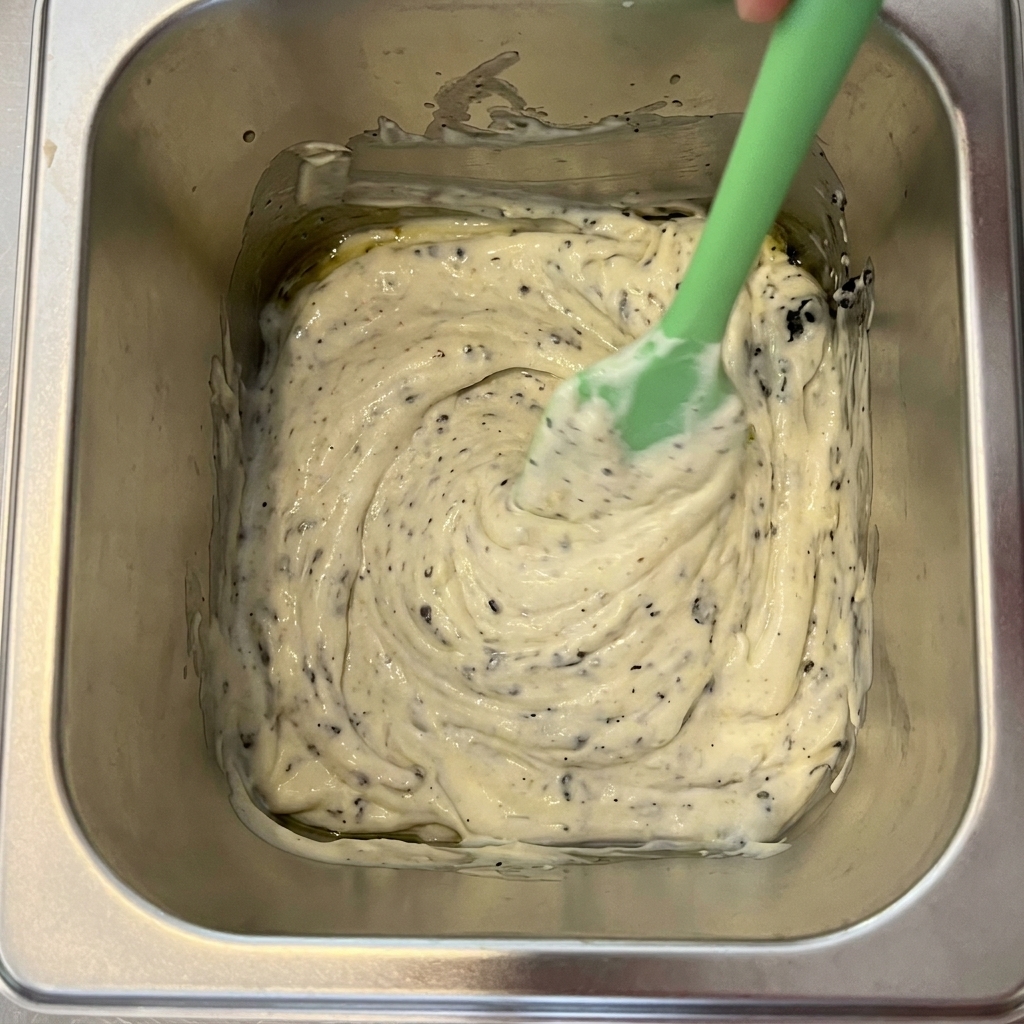 Trufa negra, mayonesa y aceite de oliva mezclándose en un recipiente de metal.