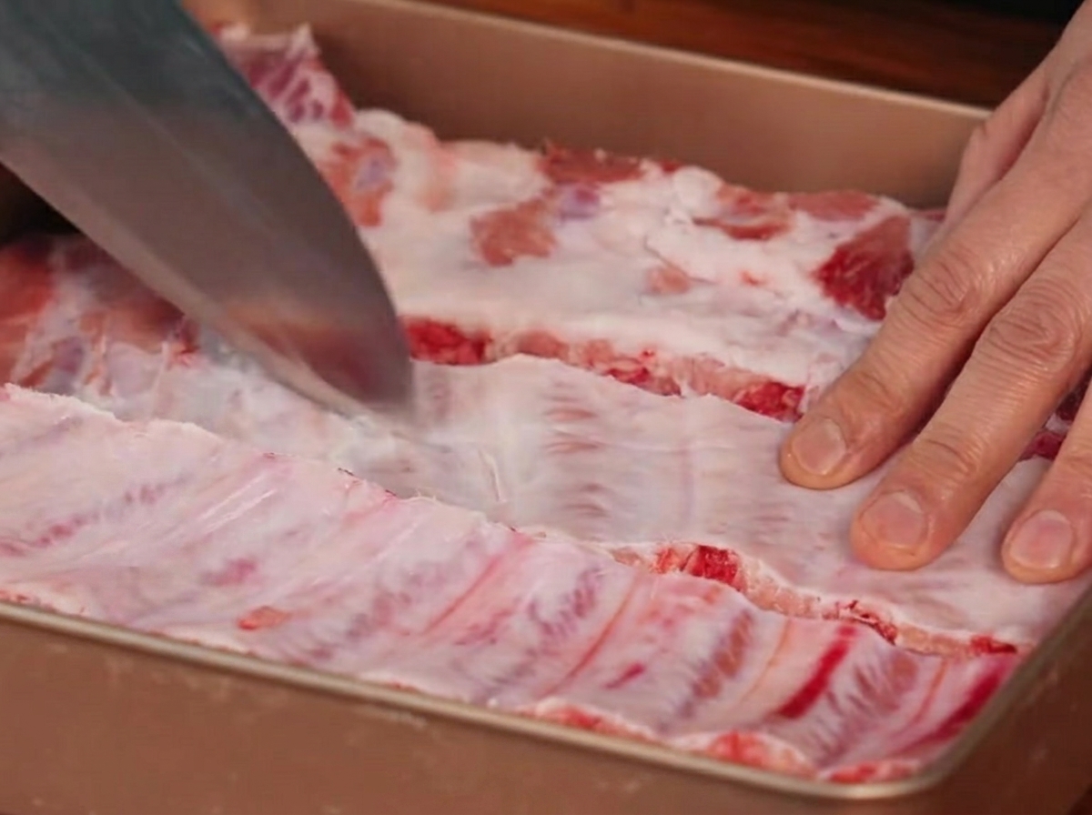 Un cuchillo haciendo incisiones en la membrana ubicada en la parte posterior de las costillas.