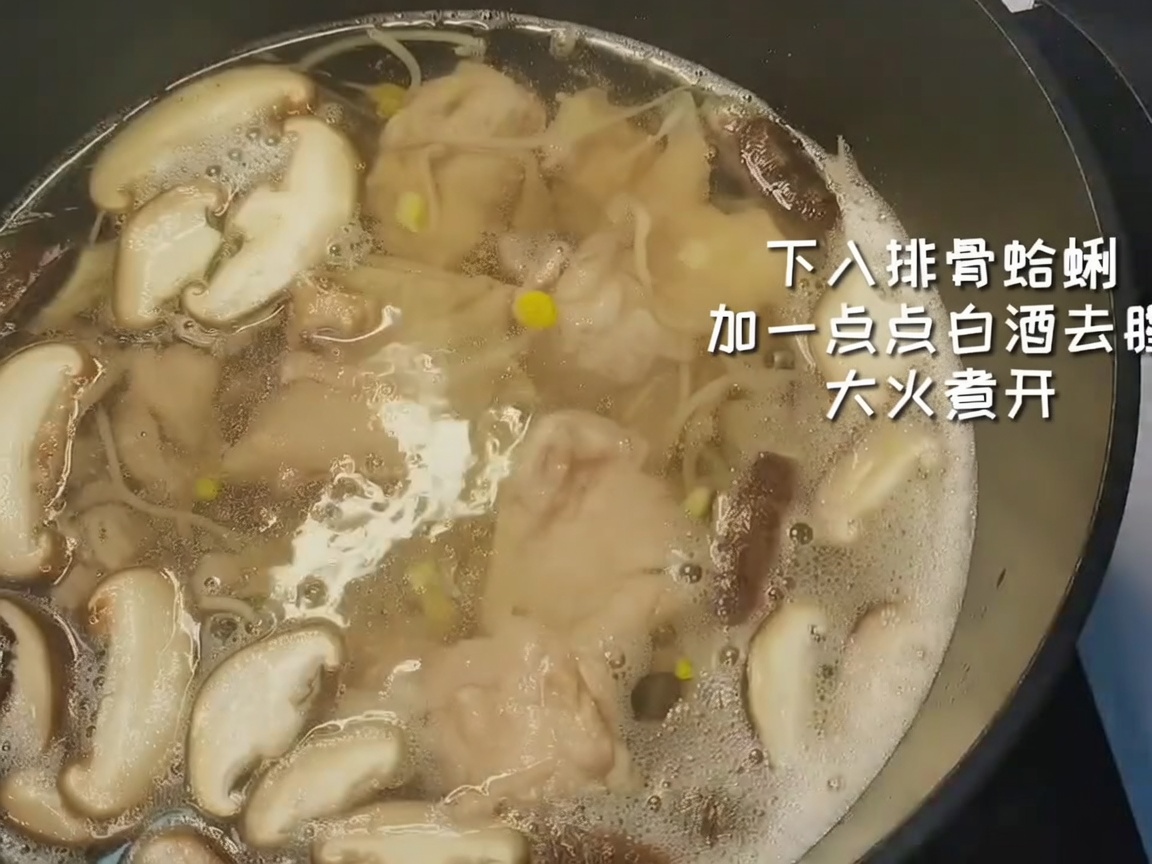 Costillas de cerdo blanqueadas y almejas limpias siendo añadidas a una olla con verduras y agua hirviendo.